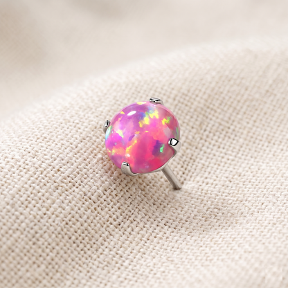 Opal stud earring on a beige fabric background