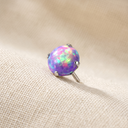 Opal stud earring on a beige fabric background