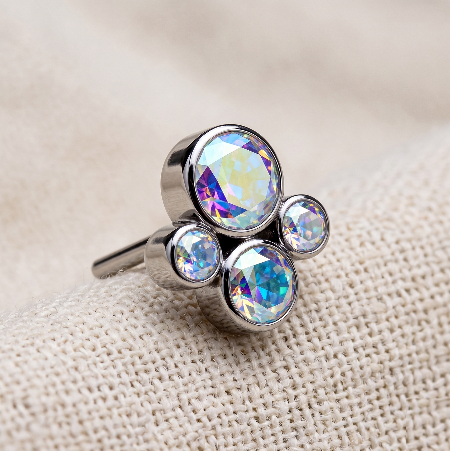 Silver ring with multicolored gemstones on a beige fabric background
