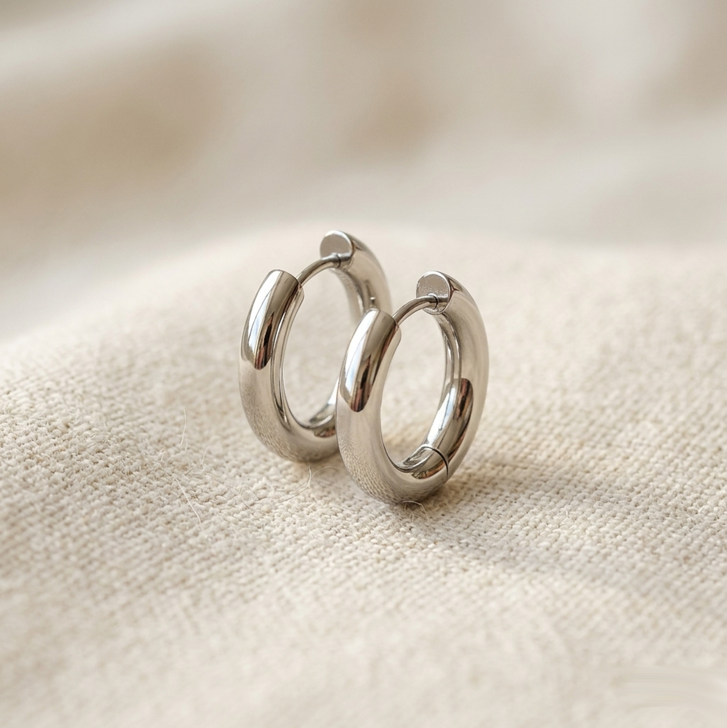 Silver surgical steel thick 5mm hoop earrings on cream linen fabric