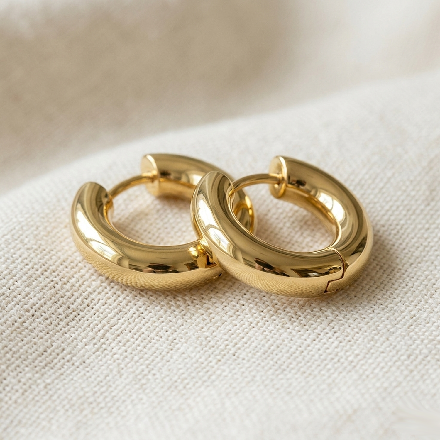 Gold surgical steel thick 5mm hoop earrings on cream linen fabric