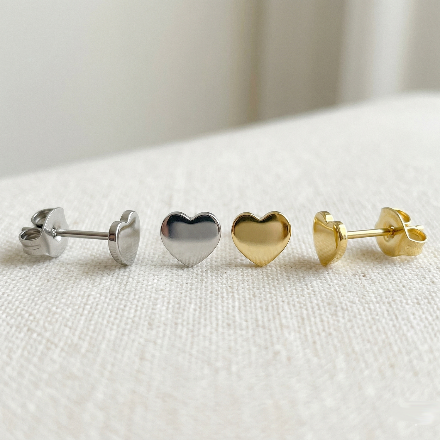 Silver and gold titanium heart stud earrings side by side comparison