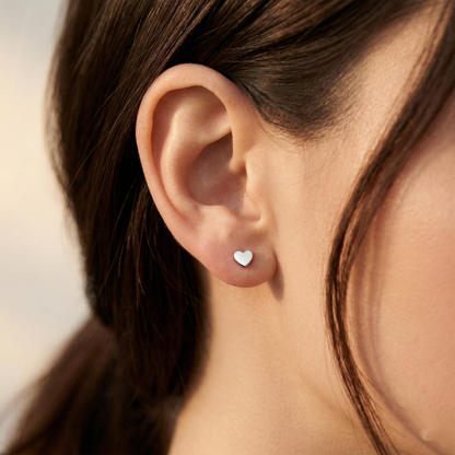 Silver titanium heart stud earring shown on ear with earlobe piercing