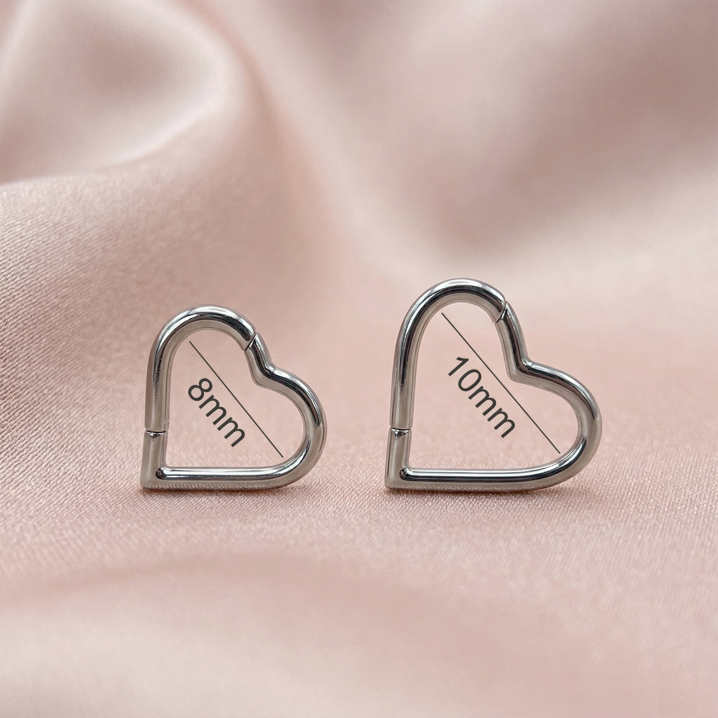 Silver and gold titanium heart hinged hoop rings side by side