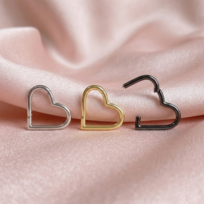Silver gold and black titanium heart hinged hoops on pink silk fabric