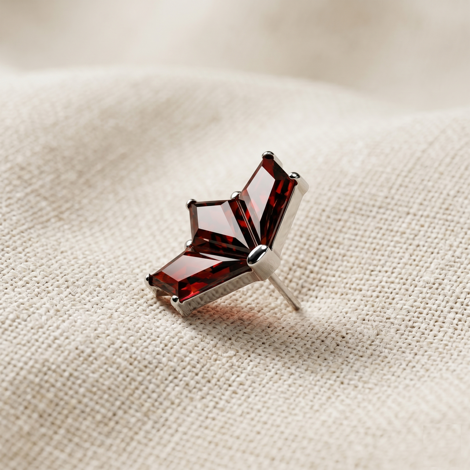 Red gemstone earring on a beige fabric background