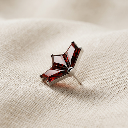Red gemstone earring on a beige fabric background