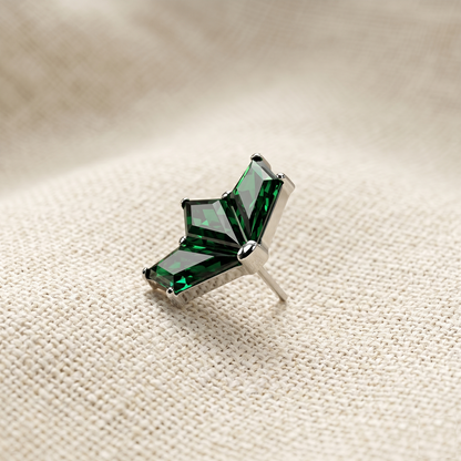 Green gemstone brooch on a beige fabric background