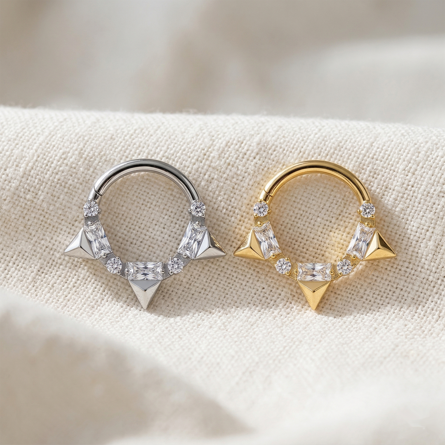 Silver and gold titanium CZ spike hinged hoop rings on white background