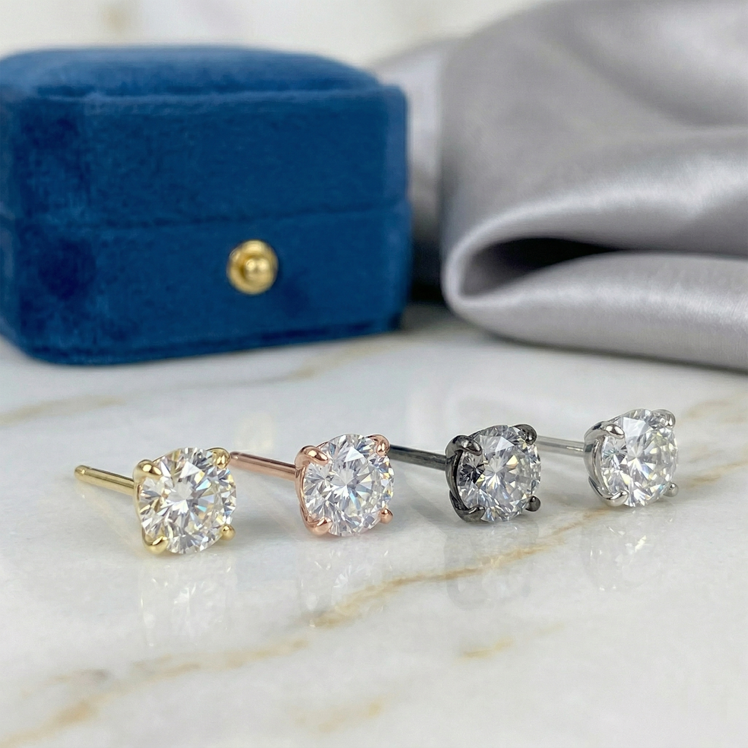 Gold titanium clear CZ threadless stud lifestyle photo on blue velvet
