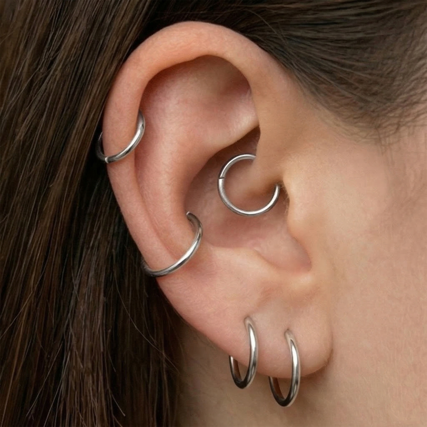 Silver titanium hinged hoop shown on ear helix piercing
