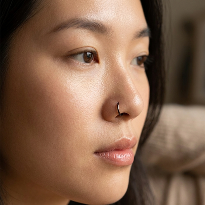 Black titanium hinged hoop shown on nose piercing