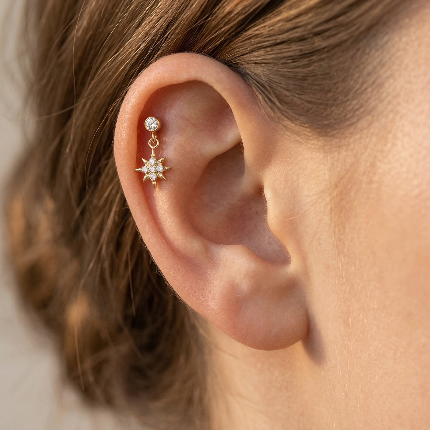Titanium north star dangle stud shown on ear with helix piercing
