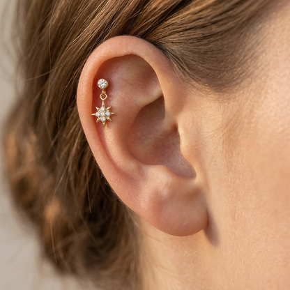 Titanium north star dangle stud shown on ear with helix piercing
