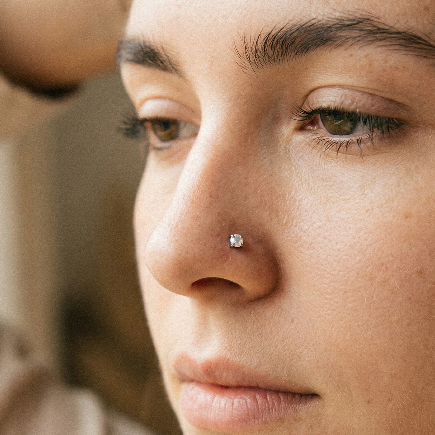 Titanium CZ prong stud shown on nostril piercing
