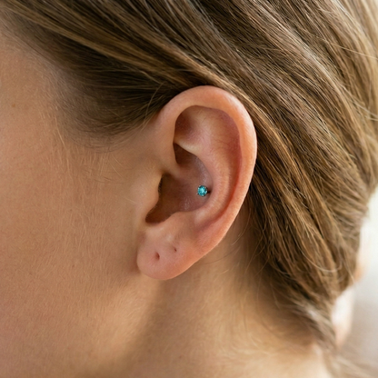 Titanium aqua CZ prong stud shown on conch piercing
