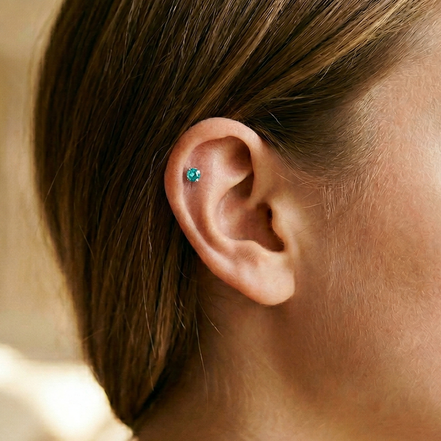 Titanium aqua CZ prong stud shown on ear with helix piercing
