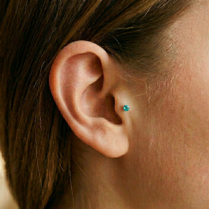 Titanium aqua CZ prong stud shown on tragus piercing
