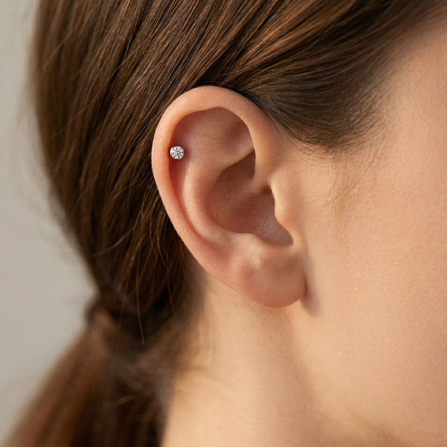 Silver titanium bezel CZ convex threaded labret shown on helix