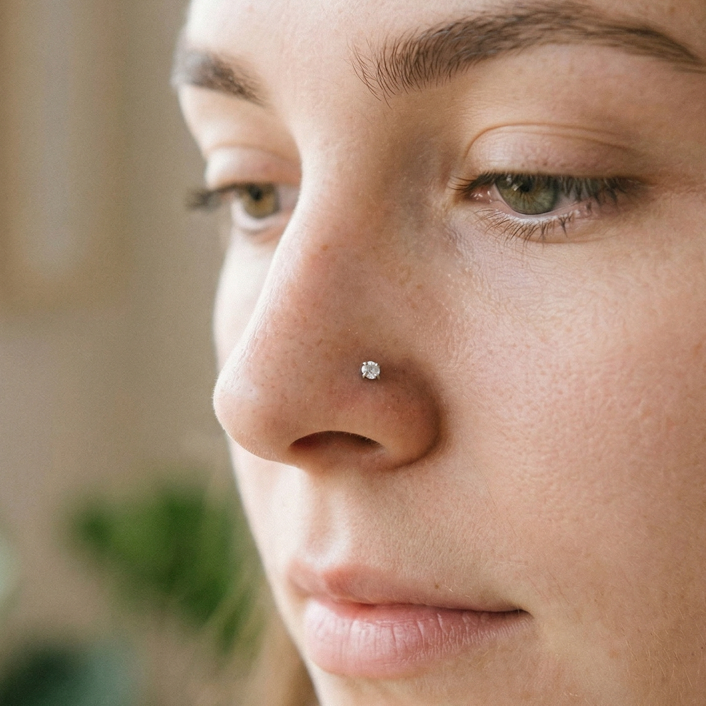 Titanium CZ prong stud shown on nostril piercing

