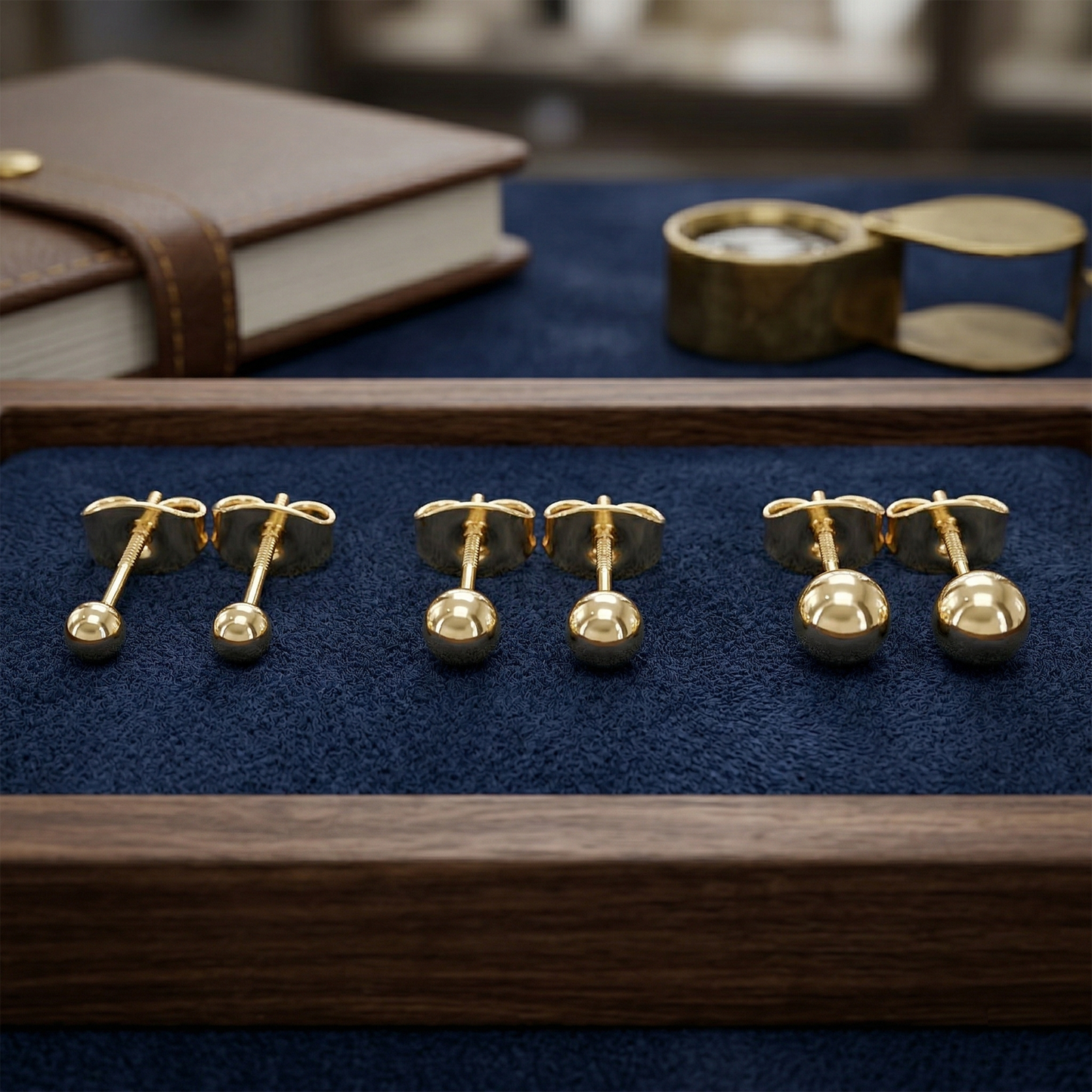 Gold titanium ball stud earrings displayed with multiple sizes