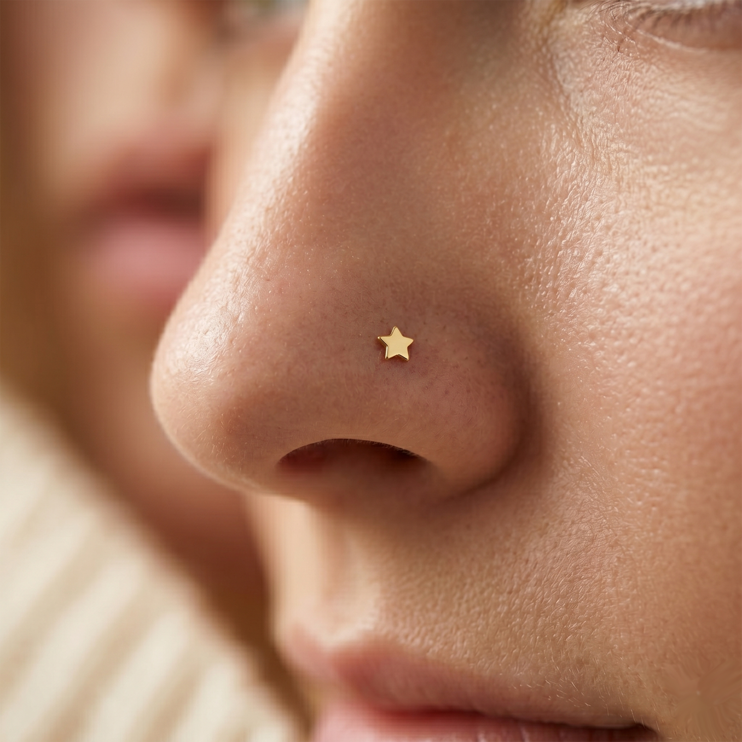 Close-up of a person wearing a gold star-shaped nose ring.