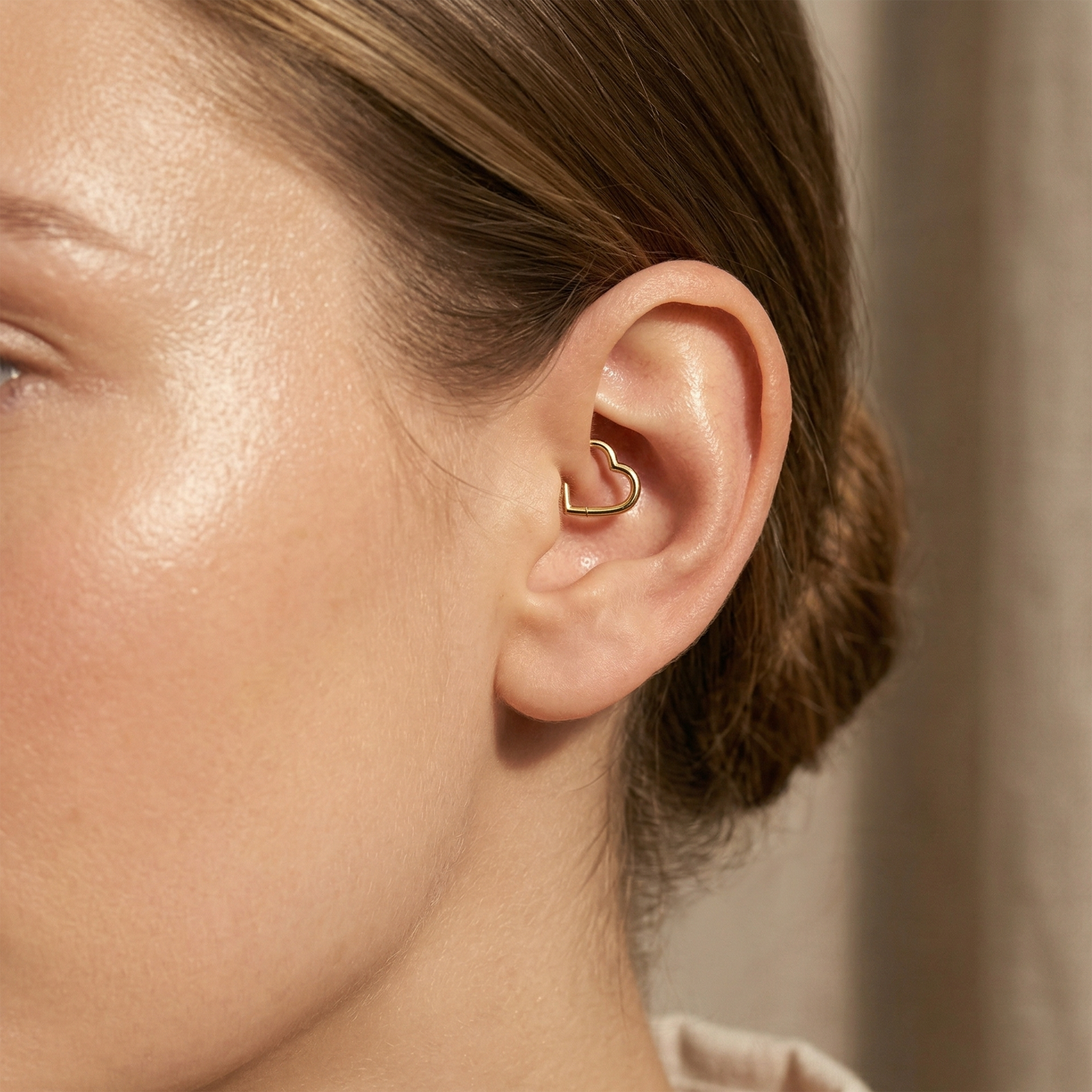 Gold titanium heart hinged hoop shown on ear in daith piercing
