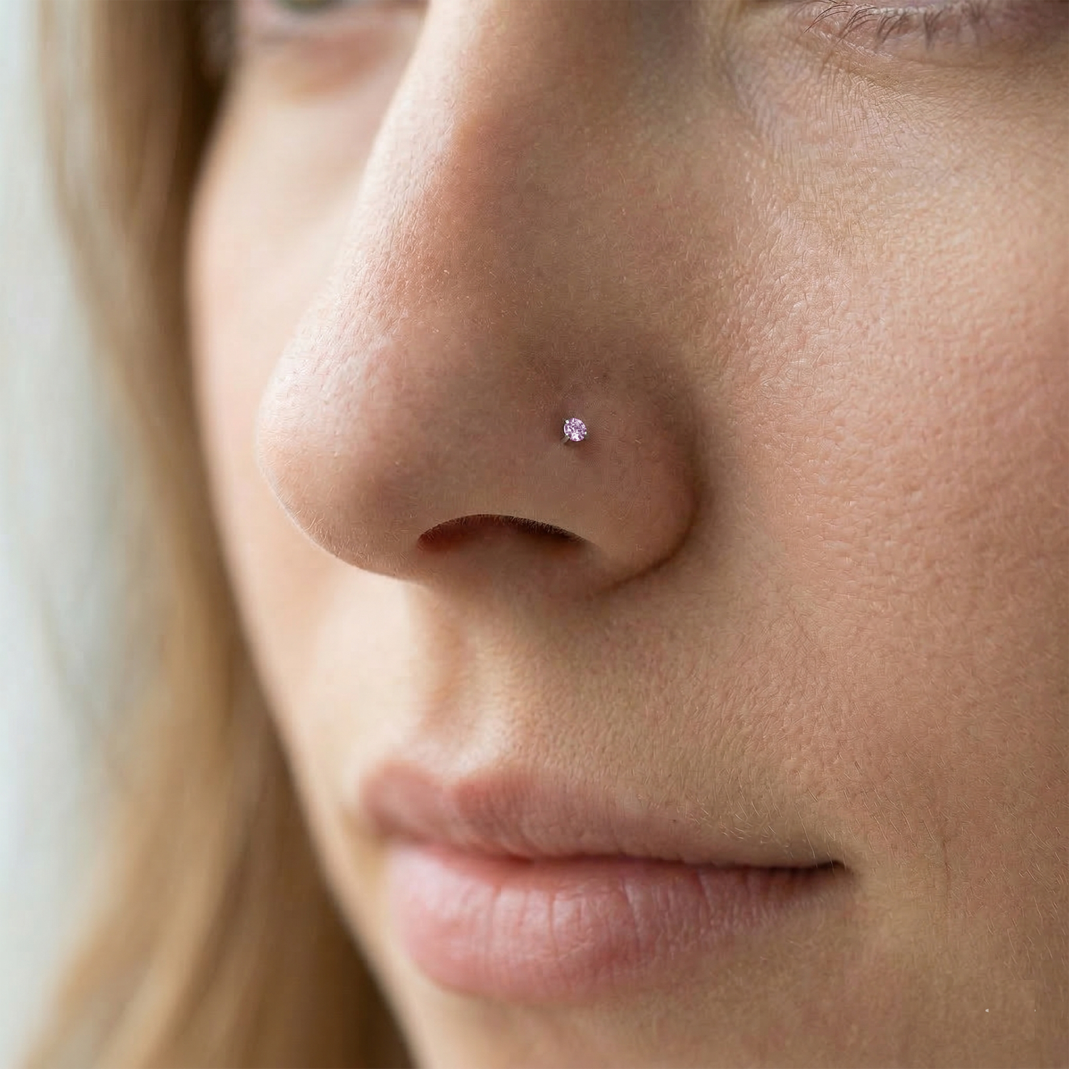 Pink CZ titanium nose screw ring on nostril
