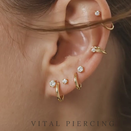 Gold titanium CZ prong stud video shown on ear with curated ear stack
