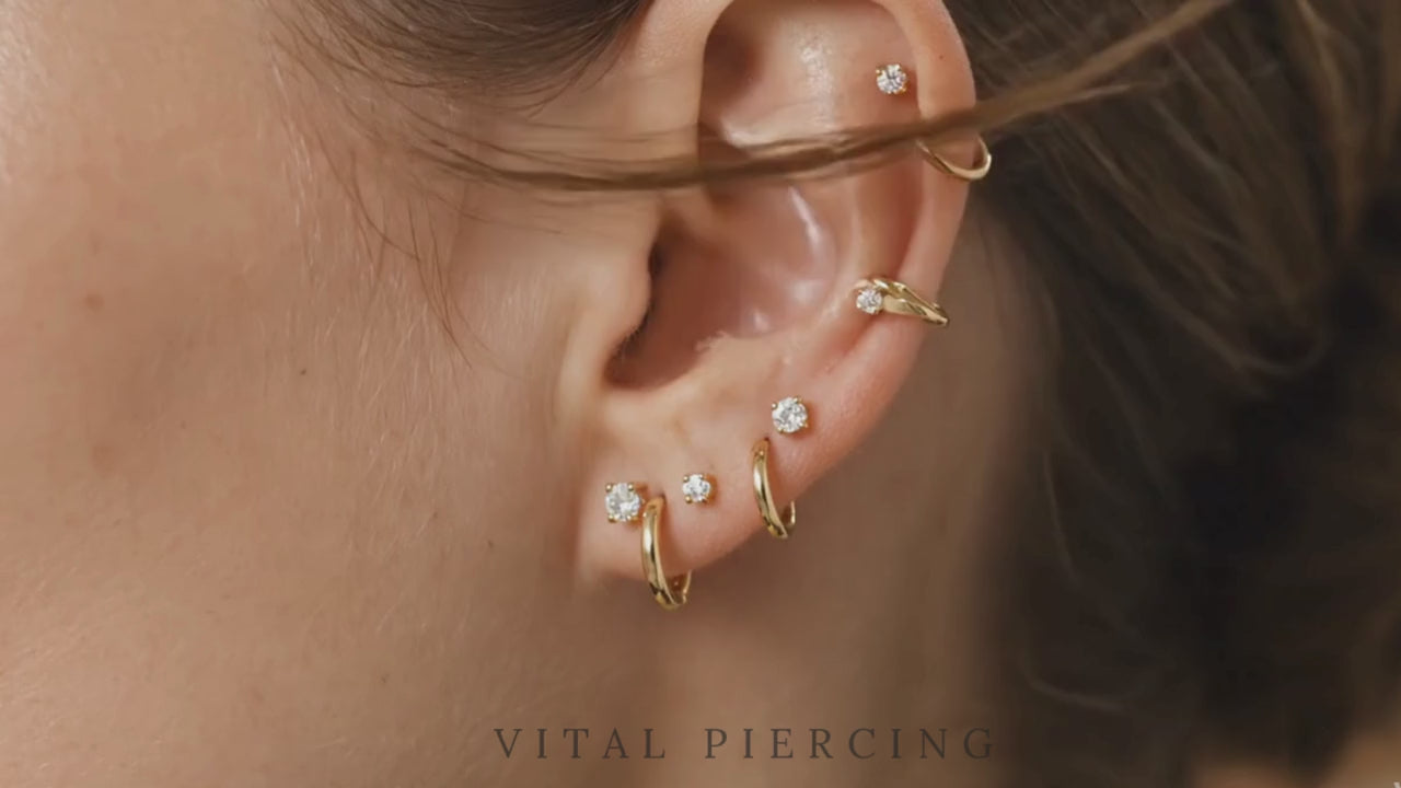 Gold titanium CZ prong stud video shown on ear with curated ear stack
