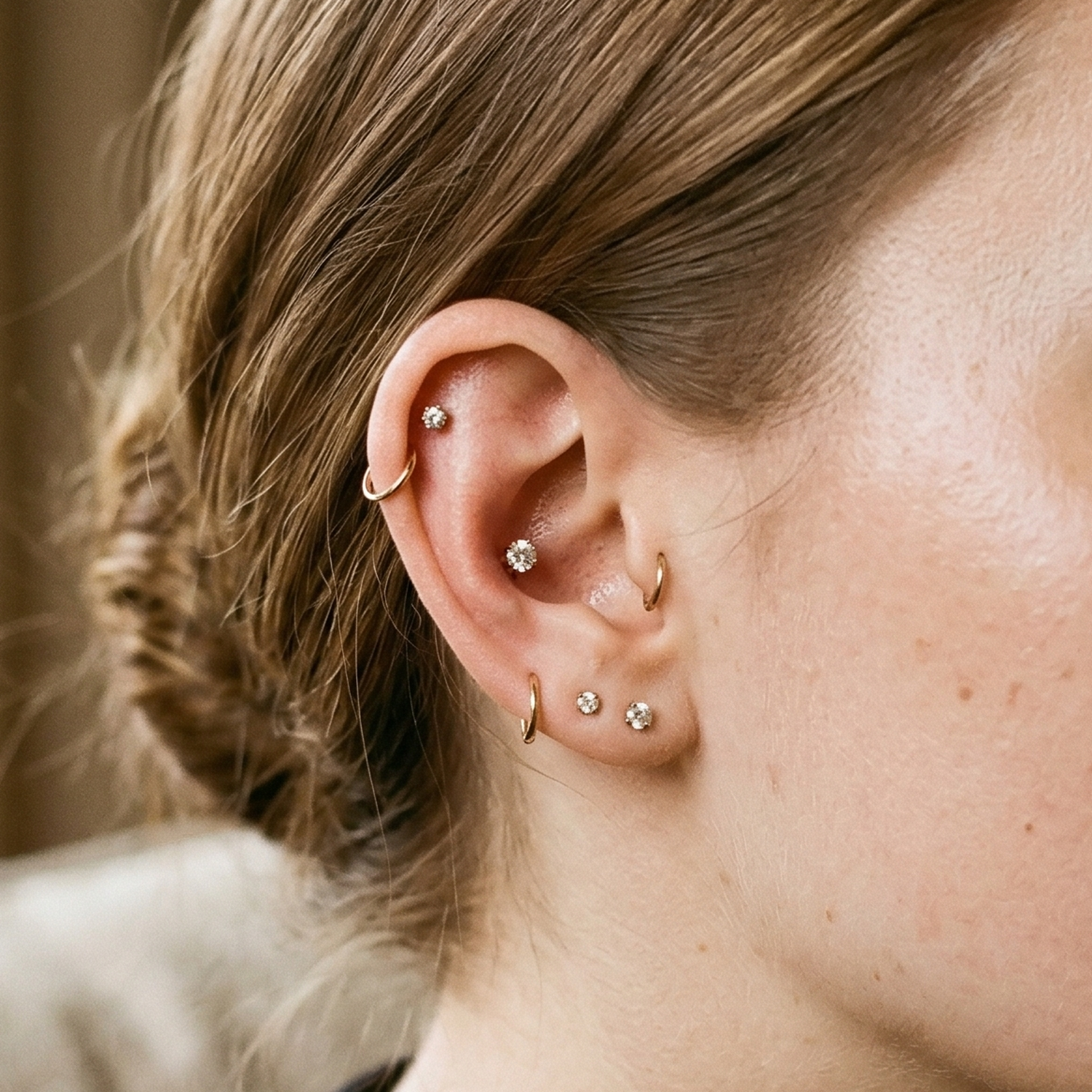 Gold titanium CZ prong stud shown on helix cartilage piercing
