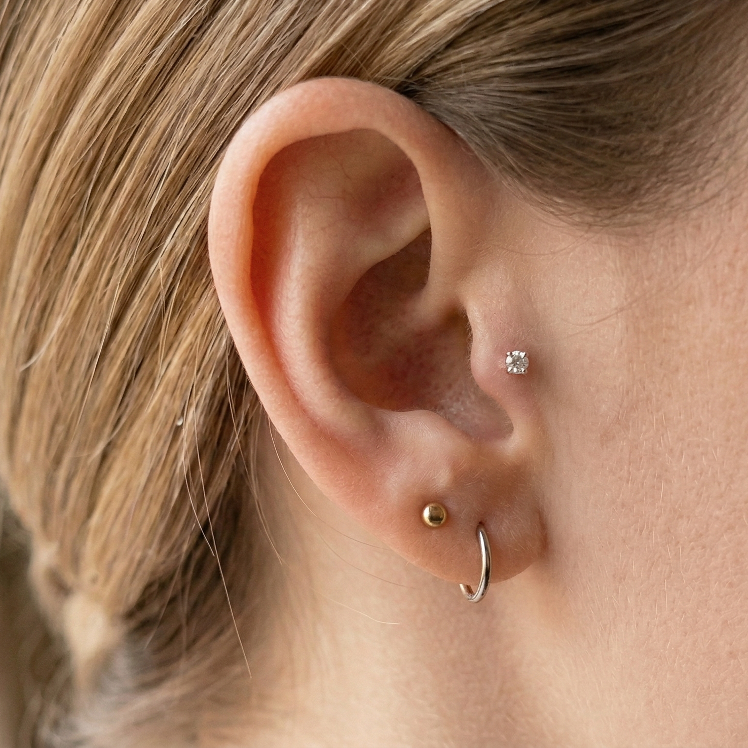 Titanium CZ prong stud shown on tragus piercing, ball stud
