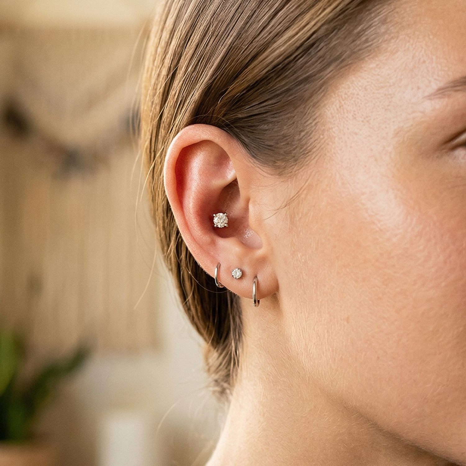 Titanium CZ prong stud shown on ear with lobe piercing and hoop