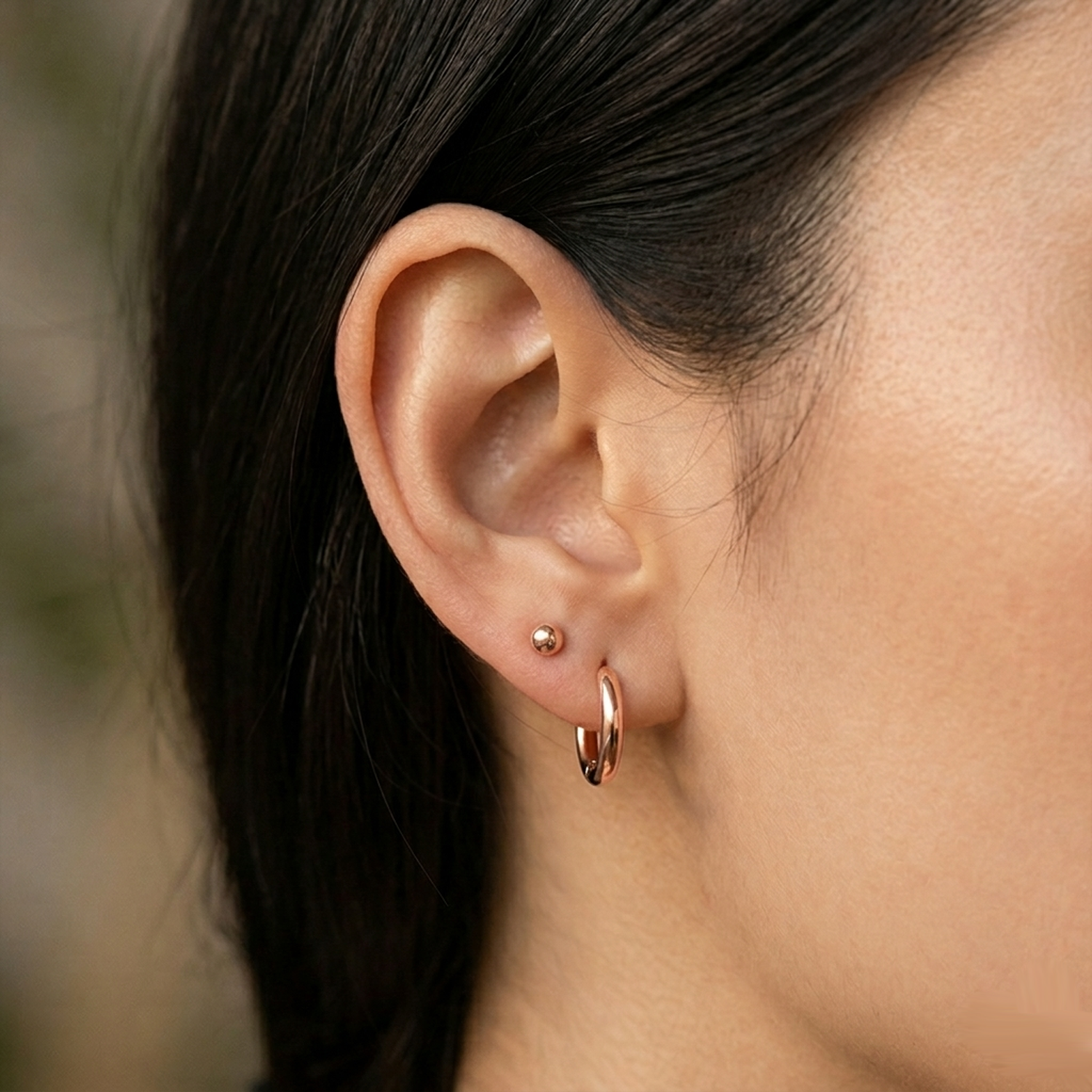 Rose gold surgical steel ball stud earrings close-up on ear with lobe piercing