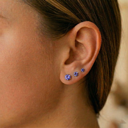 Tanzanite CZ surgical steel stud earrings shown on ear with lobe piercing