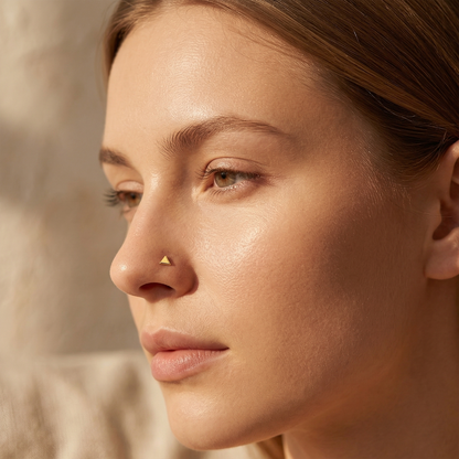 14K gold flat triangle stud shown on nose piercing