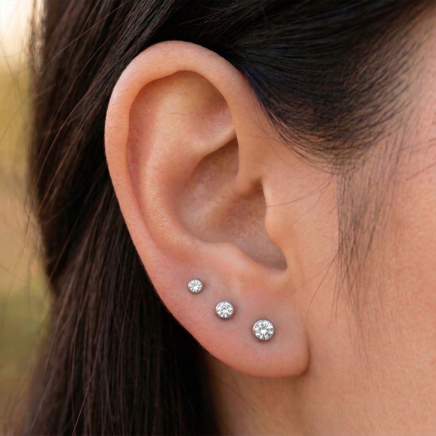 Clear CZ bezel studs shown as graduated triple lobe stack